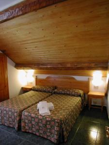 布罗托加布里酒店的一间卧室配有一张带两张桌子的床和天花板