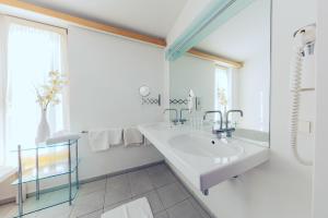 多瑙河畔克雷姆斯卡灵扈巴酒店的白色的浴室设有水槽和镜子