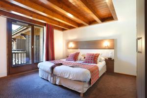 莫里永Vacancéole - Résidence Grand Massif的酒店客房设有一张床和一个大窗户
