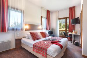 莫里永Vacancéole - Résidence Grand Massif的酒店客房,配有一张带红色毯子的床