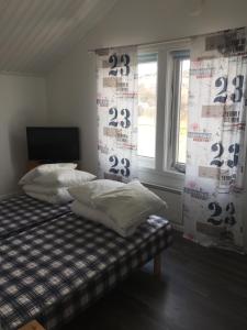 王室港Seaview Cottage Solvik - Kungshamn的一间卧室配有带两个枕头的床和窗户