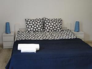 鲁恰内尼达Port przy Zeglarskiej的一间卧室配有蓝色的床和毛巾