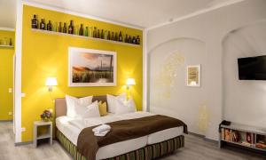 皮尔纳Pirnscher Hof - Hotel Garni的一间卧室配有一张黄色墙壁的床
