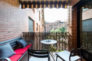 马德里市中心尊贵豪华公寓的阳台的天井配有桌椅