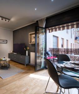 马德里市中心尊贵豪华公寓的客厅配有桌椅和电视。