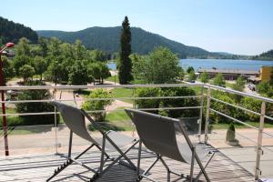 热拉梅公园小屋酒店的两把椅子坐在一个俯瞰湖泊的阳台上
