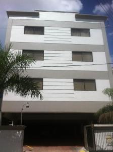 圣多明各微公寓套房酒店的一座白色的建筑,前面有棕榈树