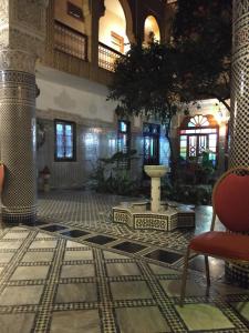 非斯Riad Les Chrifis Navette Aéroport 24 sur 24的大楼内带桌椅的大堂