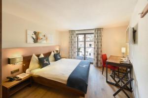 锡尔斯玛丽亚切萨马古酒店的配有一张床、一张书桌和一扇窗户的酒店客房