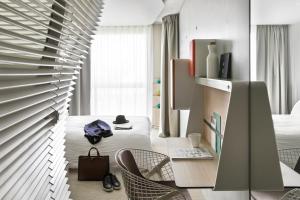 巴黎巴黎凡尔赛门奥科酒店的客房设有桌子、椅子和床。