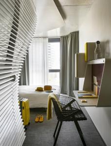 巴黎巴黎凡尔赛门奥科酒店的卧室配有床、椅子和窗户。