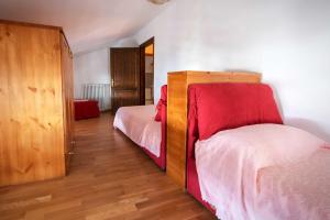 PriusoAlbergo Diffuso "Col Gentile" Socchieve的一间卧室设有两张床和木制橱柜