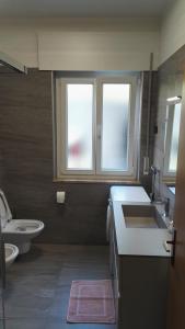 莫尔韦诺吉内斯特拉公寓的一间带水槽和卫生间的浴室以及两个窗户。