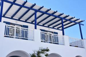 纳乌萨滨海简易别墅的白色的建筑,带有蓝色的栏杆和阳台