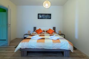 普拉Apartment Valmas的一间卧室配有一张带橙色枕头的大床