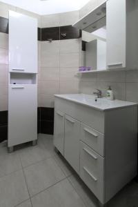 普拉Apartment Valmas的白色的厨房配有水槽和镜子