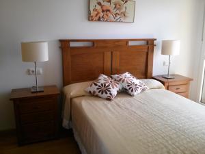 福斯Apartamento Dicar的一间卧室配有一张带2个床头柜和2盏灯的床。