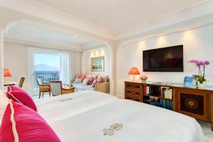 索伦托皇家大酒店的一间带白色大床的卧室和一间客厅