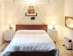 蒙得维的亚乌拉圭酒店的卧室配有一张带两张桌子的大型白色床