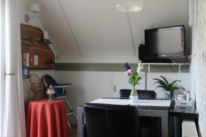Lutten霍夫凡鲁腾酒店的配有桌子、电视和椅子的房间