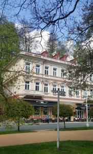 玛丽亚温泉Apartment Marienbad Hlavni 131/50的一座白色的大建筑,有很多窗户