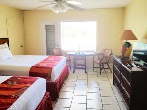 Bolongo博隆戈湾海滩度假酒店的酒店客房,设有两张床和一张桌子,椅子