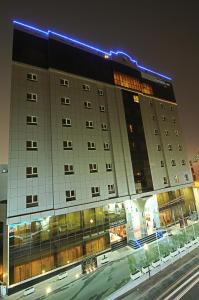 多哈Corp Executive Hotel Doha Suites的城市街道上的一个大型建筑