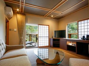 Manno阿讃琴南汤山荘日式旅馆的带沙发和玻璃桌的客厅