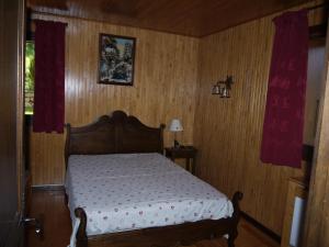 瓦尔莫雷尔Chalet la Ravine的卧室配有一张床铺,位于带木墙的房间内