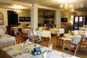 弗朗斯胡克克莱因瓦特瓦尔河滨旅馆的用餐室配有白色桌椅和吊灯。