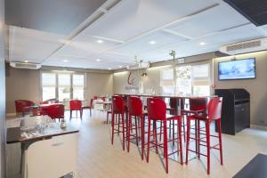 桑特钟楼圣特酒店的一间设有红色椅子的餐厅和一间位于客房内的酒吧