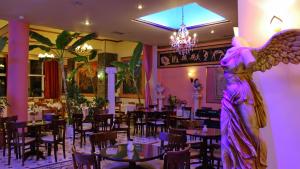 卡兰巴卡科斯塔法迈斯酒店的餐厅的天使雕像,配有桌椅