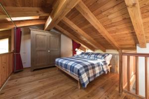 奥斯塔L'Atelier du Temps - Le matin clair的一间卧室设有一张床和木制天花板