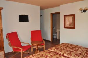 Cerezo de Abajo兰加酒店的一间卧室配有一张床、两把椅子和一台电视