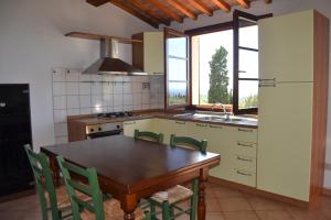 瓜尔迪斯塔洛Appartamento Belvedere的厨房配有木桌和绿色椅子