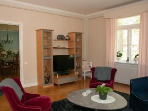 BroEkeby i Bro的客厅配有红色椅子和电视