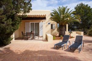 埃斯普霍斯Vivendes Adelina - Escapada Formentera的房屋前设有带桌椅的天井。