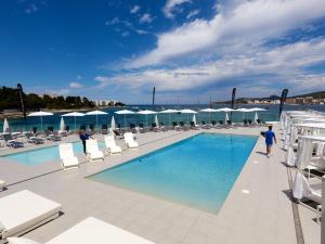 圣安东尼奥湾Axel Beach Ibiza - Adults Only的游泳池周围设有椅子和人