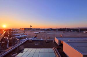 美因河畔法兰克福我的云端过境酒店 - 只允许乘坐国际航班的客人入住！的日落时分停机的机场景观