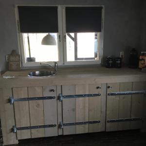 NistelrodeHof van donzel的带水槽的厨房台面和2扇窗户