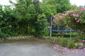 圣马洛Maison Coetquen的一个带粉红色花卉和围栏的停车场