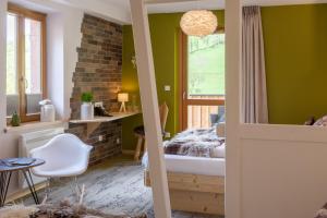 圣玛丽欧米讷Hostellerie Les Bagenelles的一间卧室设有绿色的墙壁、一张床和窗户