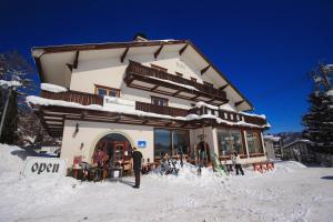 白马村MARILLEN HOTEL by Hakuba Hotel Group的站在建筑物前的雪中,站在一个男人