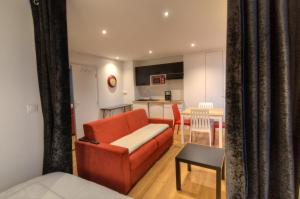 安锡Les Quais d'Annecy的一间带红色沙发的客厅和一间厨房