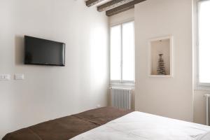 威尼斯里亚托套房1602公寓的白色卧室设有壁挂式平面电视
