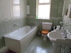 贝尔马利特Leam Cottage的带浴缸、卫生间和盥洗盆的浴室