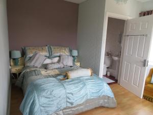 贝尔马利特Leam Cottage的一间卧室配有一张带蓝色棉被的床