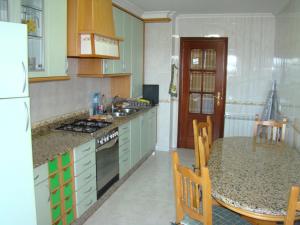 维拉加尔西亚·德·阿劳萨Apartamento Valle Inclán的厨房配有绿色橱柜和带台面的桌子