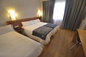 塔拉桑纳阿拉贡布鲁哈斯伊露酒店的酒店客房设有两张床和窗户。