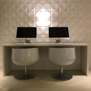 杜伊斯堡孔蒂杜伊斯堡酒店-索拉酒店的合作伙伴的两张电脑显示器坐在一张桌子上,有两把椅子